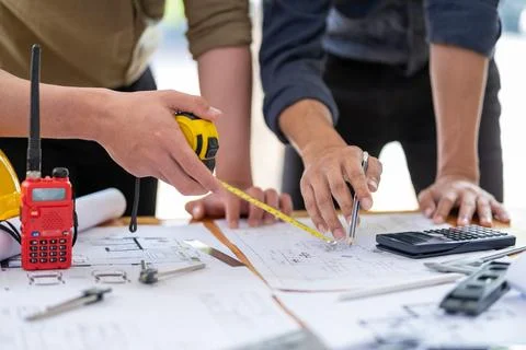 Young engineer architect sketching drawing project plan building construction Fotos de archivo
