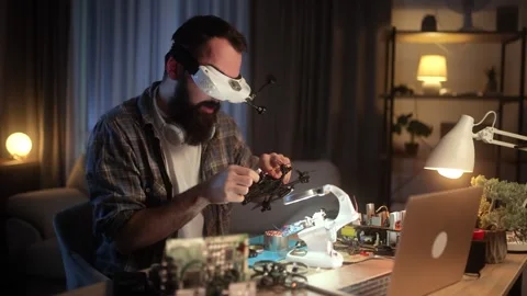 A young engineer with a beard is assembling, soldering, programming, and testing Video stock 273175780