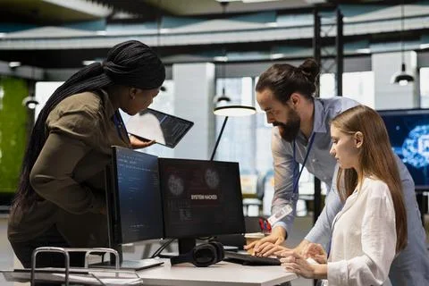 Young engineer blocking hacker in office, requesting help from IT experts Stock Photos