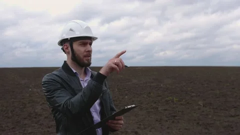 Young engineer builder in a white helmet writes on the tablet. Stock Footage 153271416
