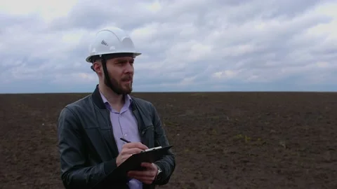 Young engineer builder in a white helmet writes on the tablet Stock Footage 153275575