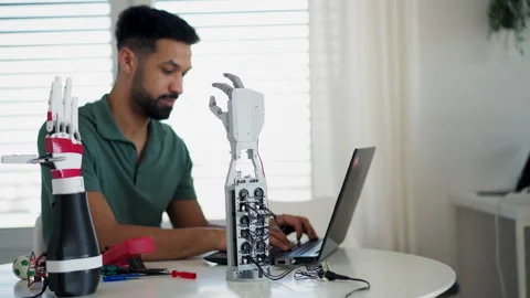Young engineer building and programming a robotic arm at home. 스톡 동영상 310209568