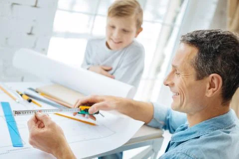 Young engineer checking measures on tape Stock Photos