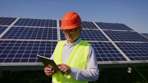 An young engineer is checking with tablet an operation of sun and cleanliness on Stock Footage 154024593