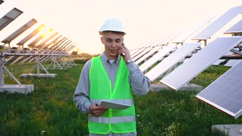 A young engineer with a folder talks on the phone as he walks through. Stock Footage 140205328