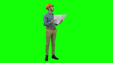 Young engineer in helmet checking construction drawings on a Green Screen Vídeos de archivo 71205014