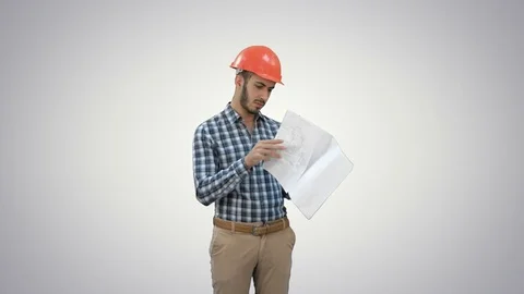 Young engineer in helmet checking construction plan on white background Stock Footage 73633232