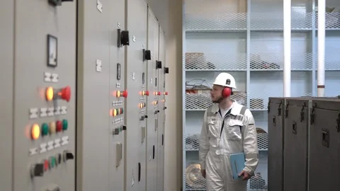 Young engineer in helmet checks the performance of a power plant Stock Footage 119986272