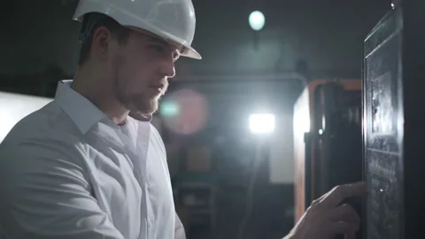 Young engineer in helmet controls the process on the factory Stock Footage 114504727