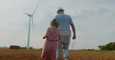 Young engineer with his daughter in a field with wind turbines. Stock Footage 209551104