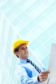 Young engineer looking at paperwork by office building Fotos de archivo