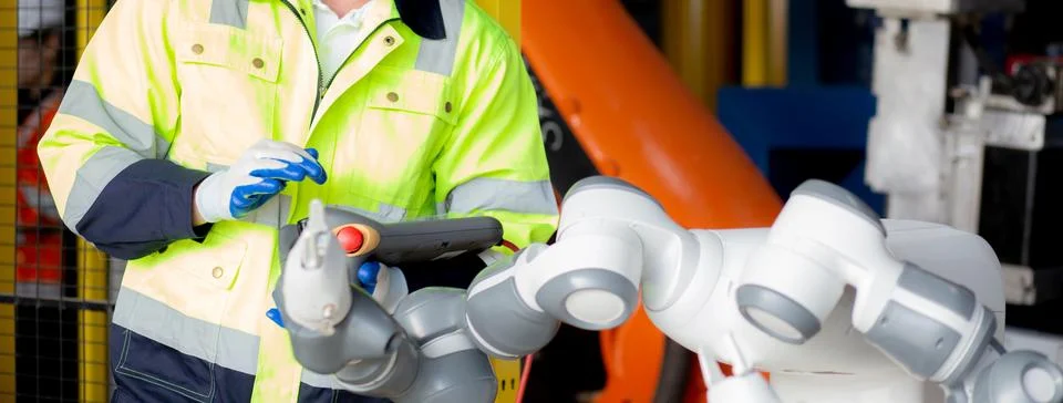 Young engineer man checking and maintenance machine robot arms technology i.. Stock Photos