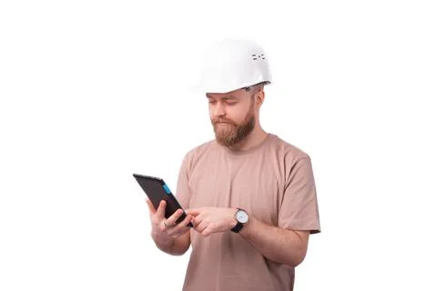 Young engineer man using tablet and wearing hardhat over white background Stock Photos