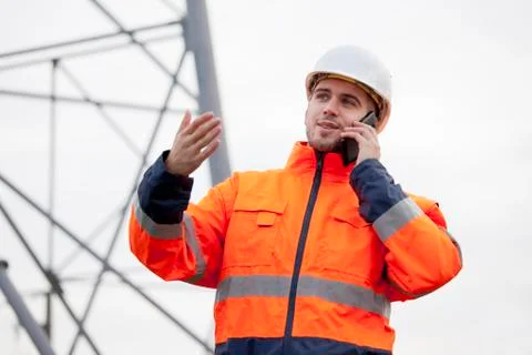 Young engineer or foreman talking  on smart phone on a oil platform or constr Stock Photos