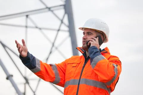 Young engineer or foreman talking  on smart phone on a oil platform or constr Stock Photos