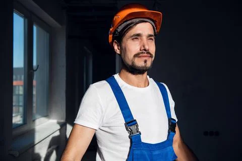 Young engineer puts orange hard hat on his head Stock Photos