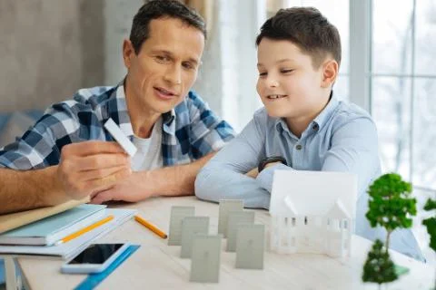 Young engineer showing solar panel model to his son Stock Photos