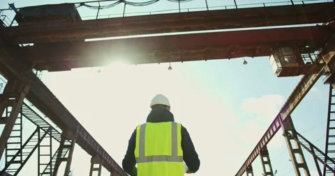 Young engineer standing with blueprint at construction site Video stock 277595891