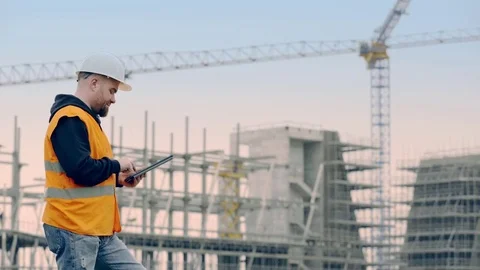 Young engineer with the tablet controls the work on site Stock Footage 72828230