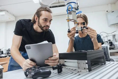 Young engineer team working in Robotic lab test program robot prototype. Ro.. Stock Photos