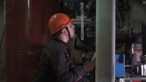 A young engineer is in a technical room. at the factory Stock Footage 105606910