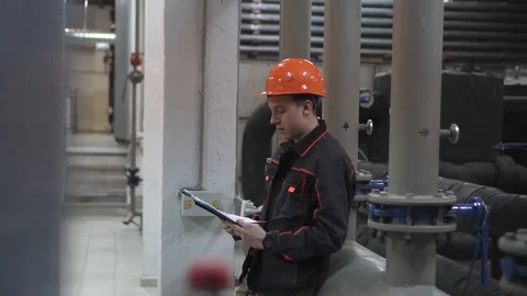 A young engineer is in a technical room. at the factory Stock Footage 105607008