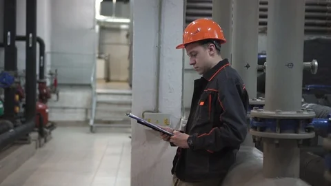 A young engineer is in a technical room. at the factory Stock Footage 105607009