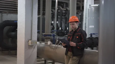 A young engineer is in a technical room. at the factory Stock Footage 105607082