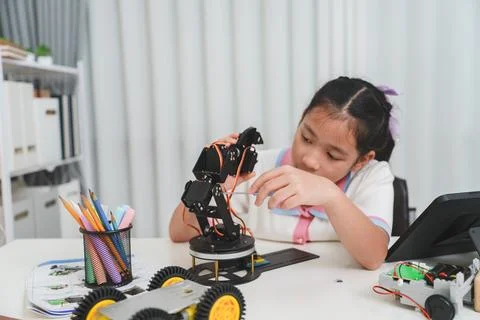 A young engineer uses a tool to build a robot. STEM and mechanics concept. 스톡 사진