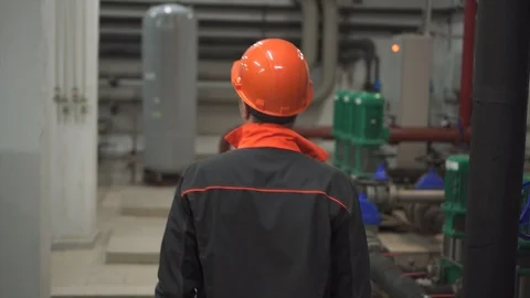 A young engineer walking is in a technical room. at the factory Stock Footage 105607210
