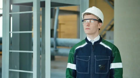 Young engineer wearing protective helmet posing looking at camera at modern Stock Footage 85573758