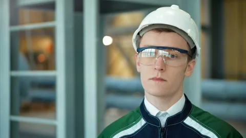 Young engineer wearing protective helmet posing looking at camera at modern Stock Footage 85574014