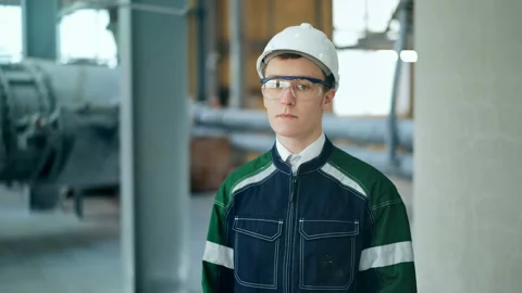 Young engineer wearing protective helmet posing looking at camera at modern Stock Footage 85575003