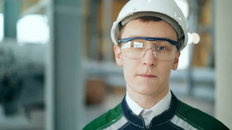Young engineer wearing protective helmet posing looking at camera at modern Stock Footage 85575200