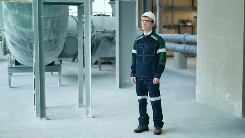 Young engineer wearing protective helmet posing looking at camera at modern Stock Footage 85575487