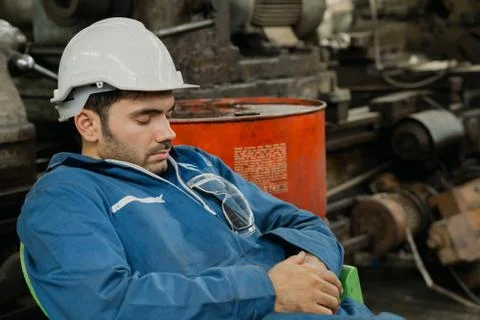 Young engineer  with white halmet  take a nap because so tired after hard work. Stock Photos