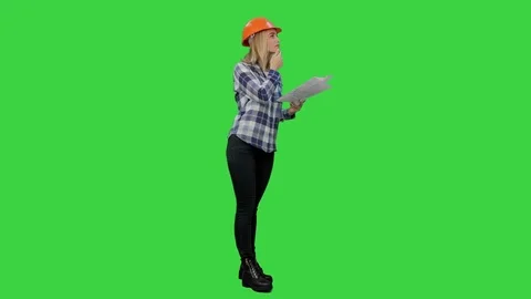 Young engineer woman reading technical drawings and analyze it on a Green Screen Video stock 73862322