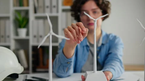 Young engineer working on a wind turbine model in an office setting during d Stock Footage 323717017