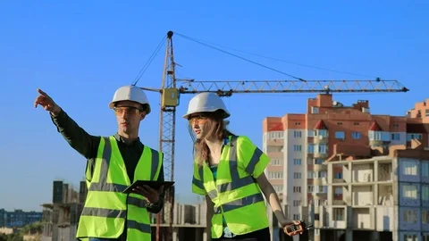 Young engineers architects guy and girl in protective helmet Video stock 128630177