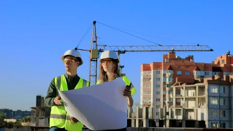 Young engineers architects a guy and a girl in a protective helmet Stock Footage 128630467