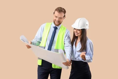 Young engineers with house plan on beige background Stock Photos