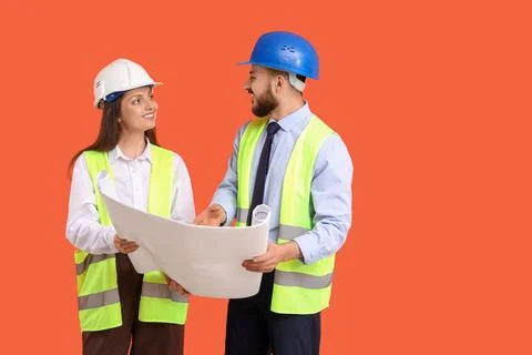 Young engineers with house plan on orange background Stock Photos