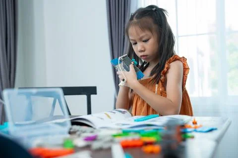 Young Engineers: multi ethnic Children engrossed in building and testing sm.. Stock Photos