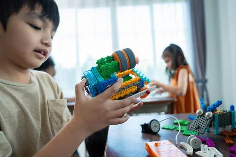 Young Engineers: multi ethnic Children engrossed in building and testing sm.. Stock Photos