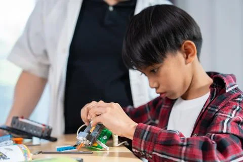 Young Engineers: multi ethnic Children engrossed in building and testing sm.. Stock Photos