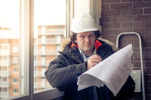 Young engineers using pen point to the blueprint paper to examine the structure Stock Photos