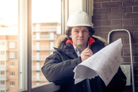 Young engineers using pen point to the blueprint paper to examine the structure Stock Photos