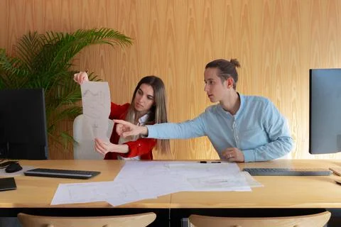 Young engineers working together on a project while making sketches Stockfoto's