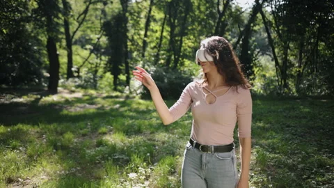 Young enjoys virtual reality glasses outdoors, brunette woman wearing vr glasses Stock-Footage 213968906
