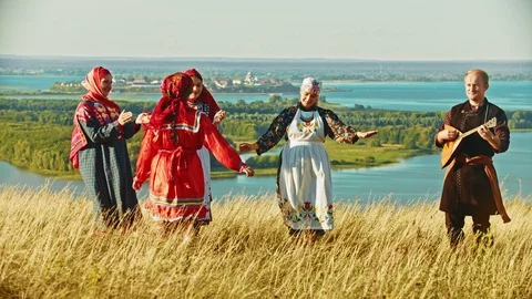 Young ensemble in traditional russian clothes dancing on the field Stock Footage 111487276